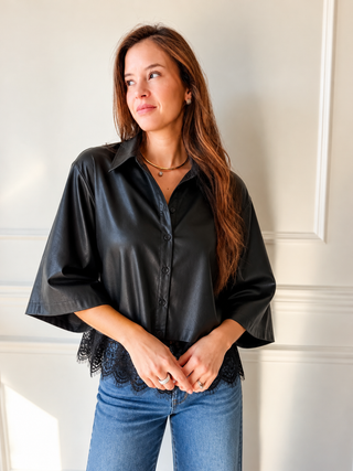 Model wearing the Nick black faux leather button-down top with wide sleeves and a scalloped lace hem.