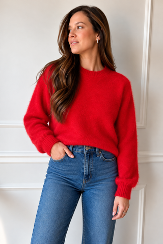Model wearing the Tracy red crewneck sweater with long sleeves and blue jeans.
